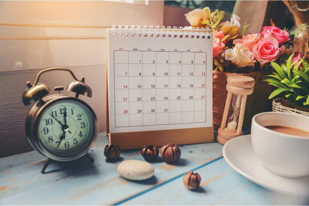 wooden clock and desk calendar sitting neatly on home office desk defining clear schedules