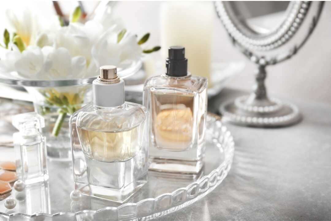 signature glass perfume bottle sitting on marble tray catching soft sunlight discovering 30 tiny luxuries every woman deserves