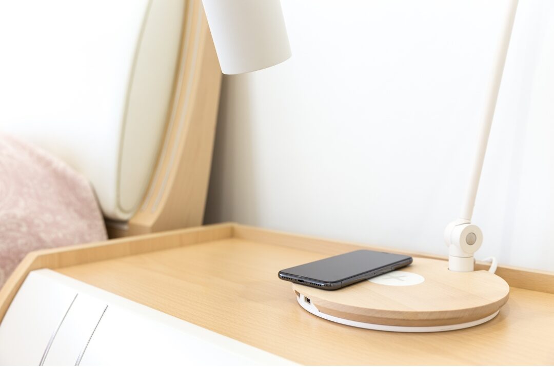 smartphone lying face down on wooden table near warm lamp