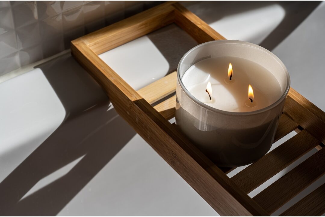 hand-poured soy candle burning gently beside small matches on ceramic tray