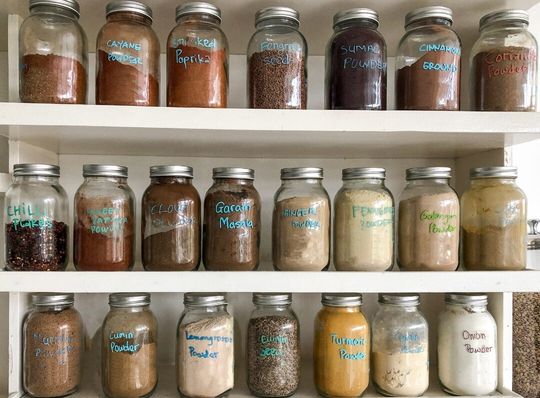 neatly arranged spice drawer with matching glass jars finding 101 things to declutter this weekend