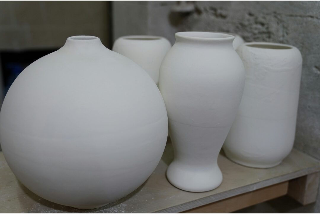 textured stoneware pottery vases displayed neatly on open wooden shelf