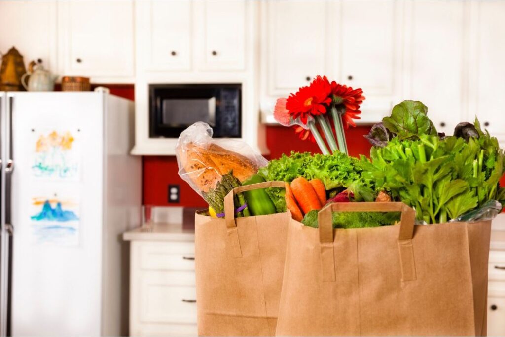 fresh grocery delivery on clean wooden kitchen counter illustrating soft life convenience