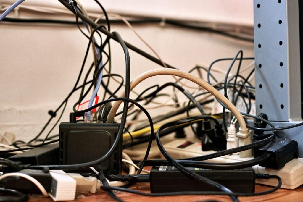 tangled phone charging cables sitting on wooden open shelf showing the one shelf that makes every house look messy