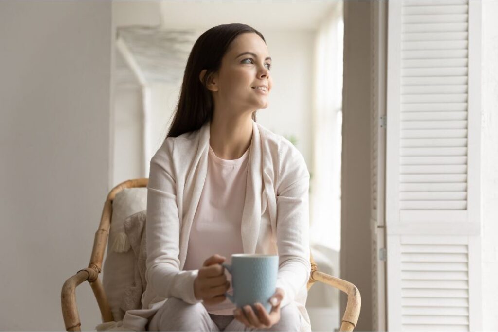 mother sitting peacefully in sunlit room illustrating the soft life checklist i wish every mom had before having kids