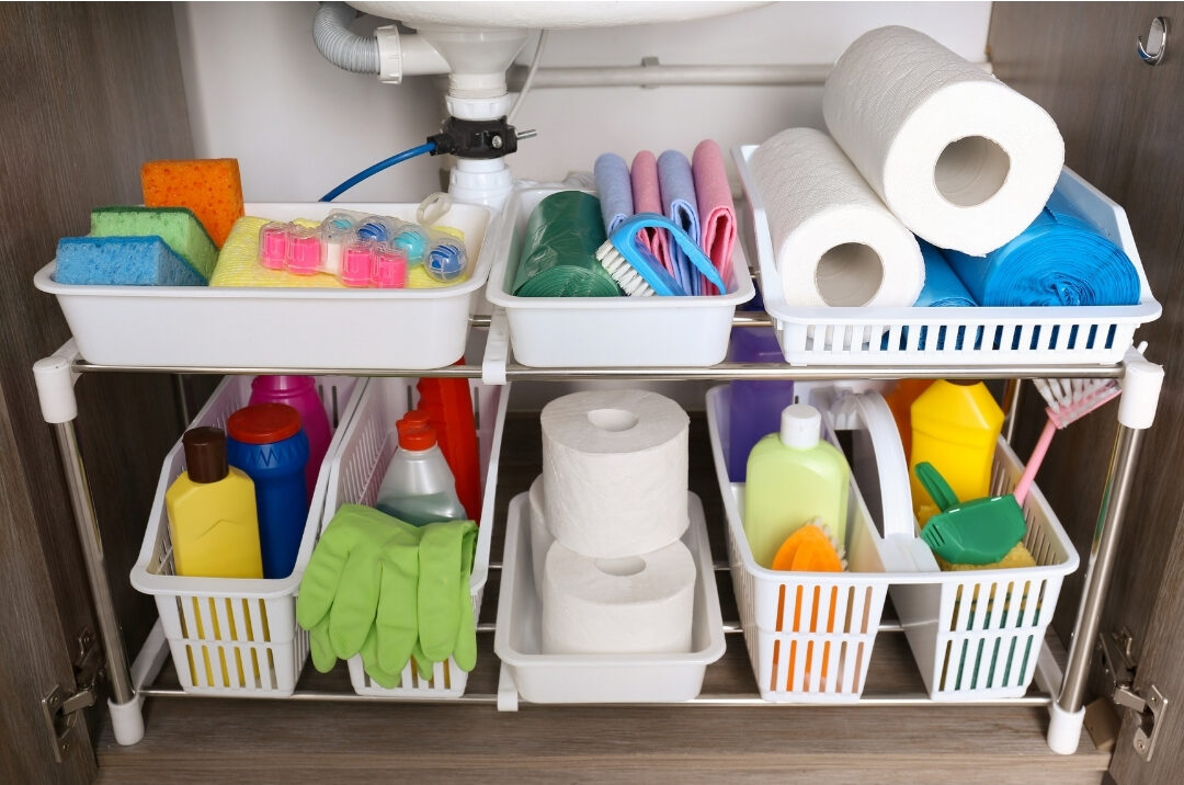 organized under sink cabinet with cleaning bottles stored in clear bins