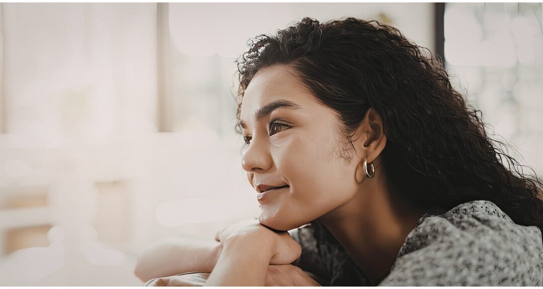 thoughtful woman resting chin on hand looking out warm sunlit window understanding feelings of failure