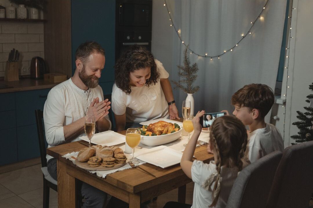 family sitting together enjoying dinner served on wooden table