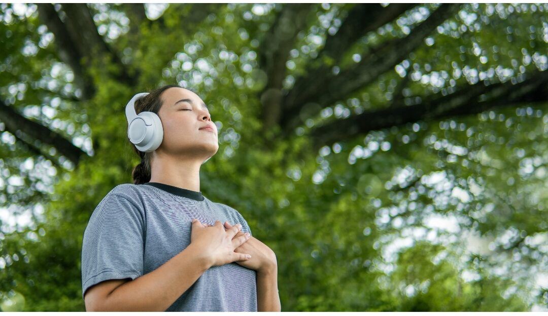 woman taking a deep calm breath in sunlit garden releasing physical tension