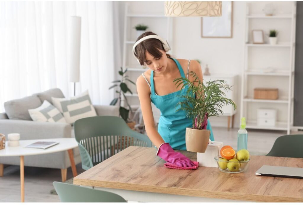 thoughtful woman wiping clean wooden dining table in quiet room highlighting nobody talks about this reason moms feel exhausted
