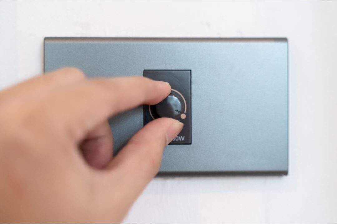 modern wall dimmer switch being adjusted by hand discovering 70 budget-friendly home upgrades that are actually worth it