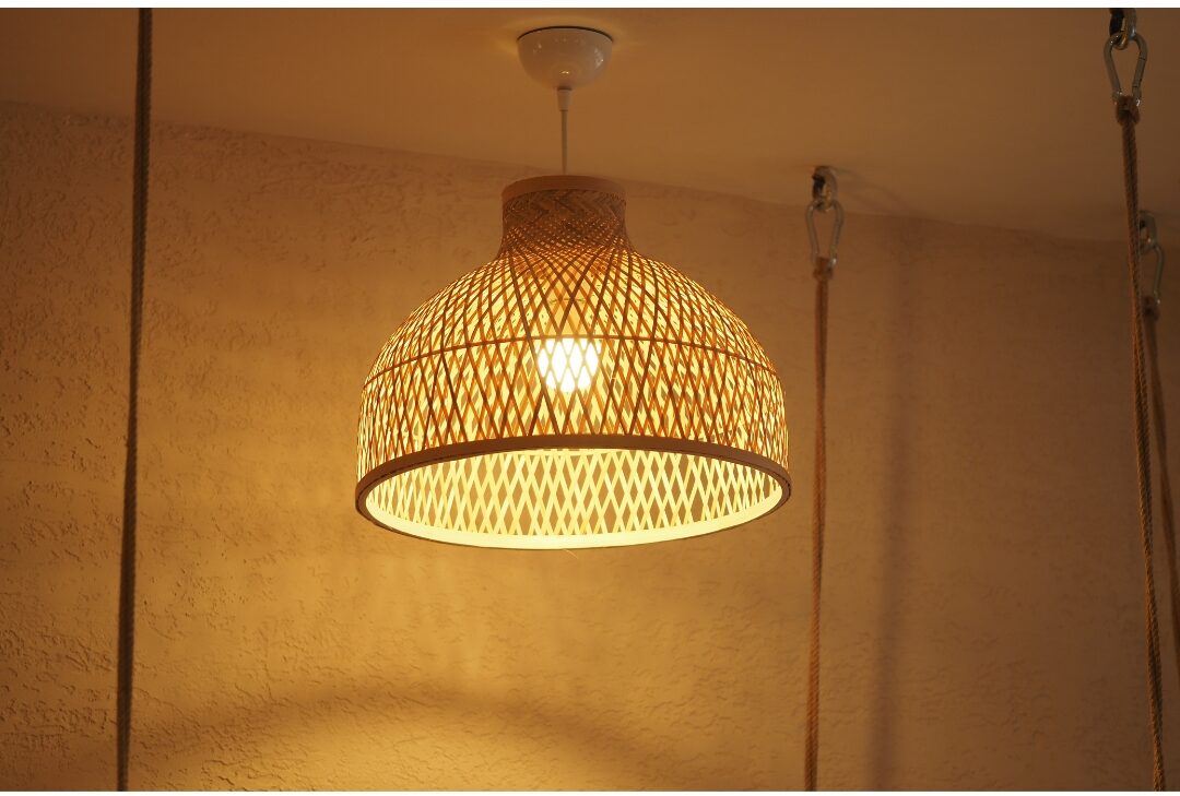 warm Edison light bulb glowing softly inside a woven rattan lamp shade
